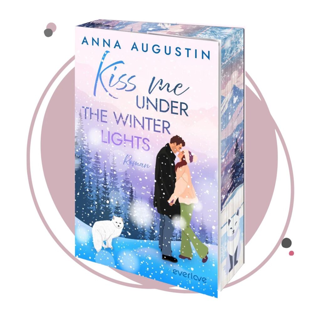 Cover des Romans Kiss me under the Winter Lights von Anna Augustin mit exklusivem Buchmädchen-Farbschnitt, illustriertes Liebespaar seitlich Hand in Hand küssend auf verschneiter Anhöhe, kleiner weißer Polarfuchs sitzt daneben, Hintergrund mit Nadelwald und verschneiten Bergen, rosa und lilafarbener Himmel mit Schneeflocken